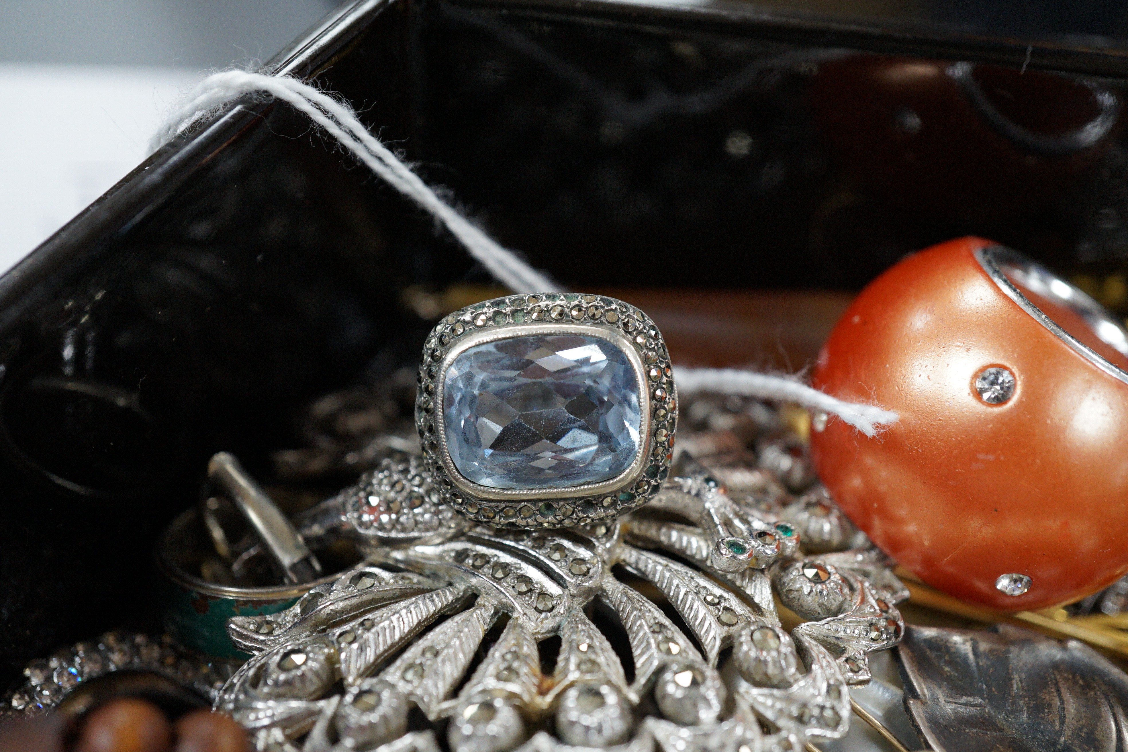 A quantity of assorted costume jewellery in a lacquer box.